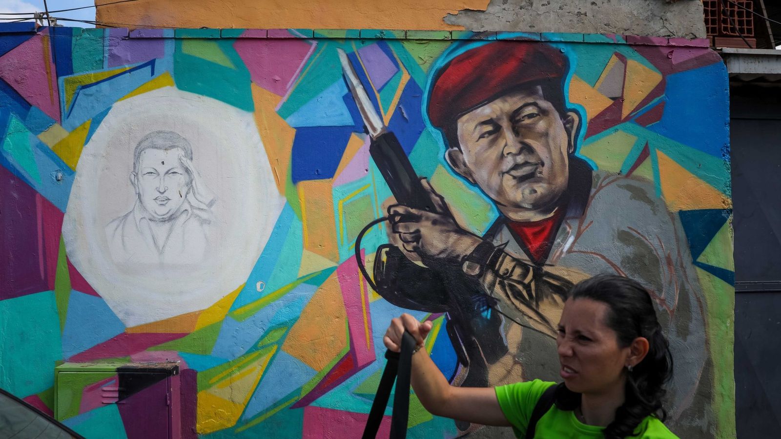 Foto: Una mujer pasa frente a un mural del presidente Hugo Chávez en Caracas, el 4 de febrero de 2019. (EFE)