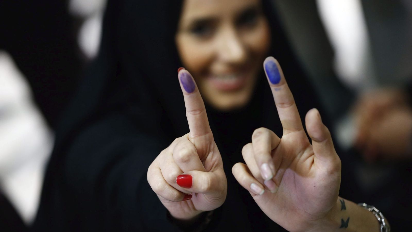 Foto: Dos chicas iraníes muestran la tinta en sus dedos tras ejercer su derecho al voto para las elecciones parlamentarias y a la asamblea de expertos en un centro electoral en Teherán (Efe).