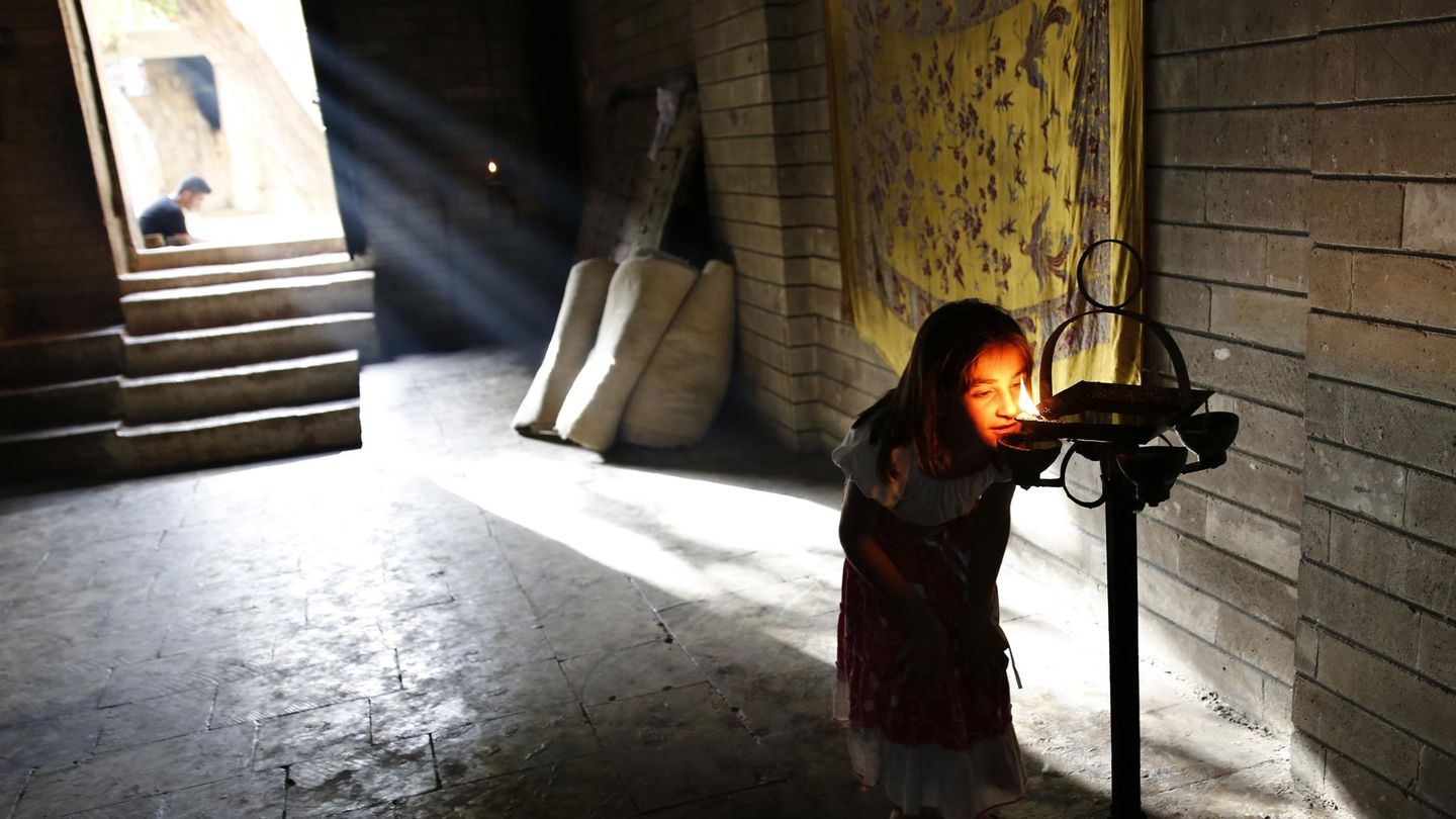 Una niña yazidí, desplazada por la violencia yihadista, reza en el templo de Lalish (Reuters). 
