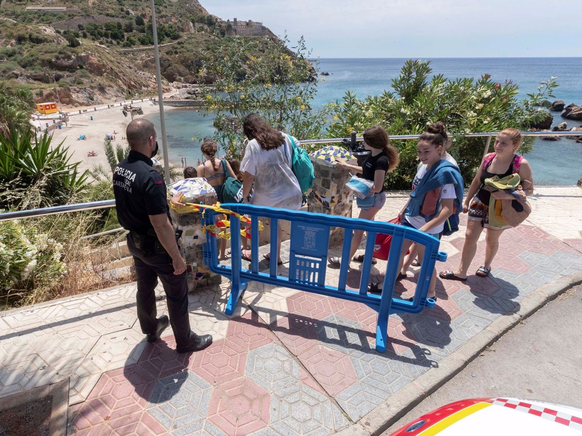 Foto: Un policía local controla el acceso de entrada a la playa de Cala Cortina en Cartagena, con un aforo de 28 personas durante el estado de alarma (EFE)