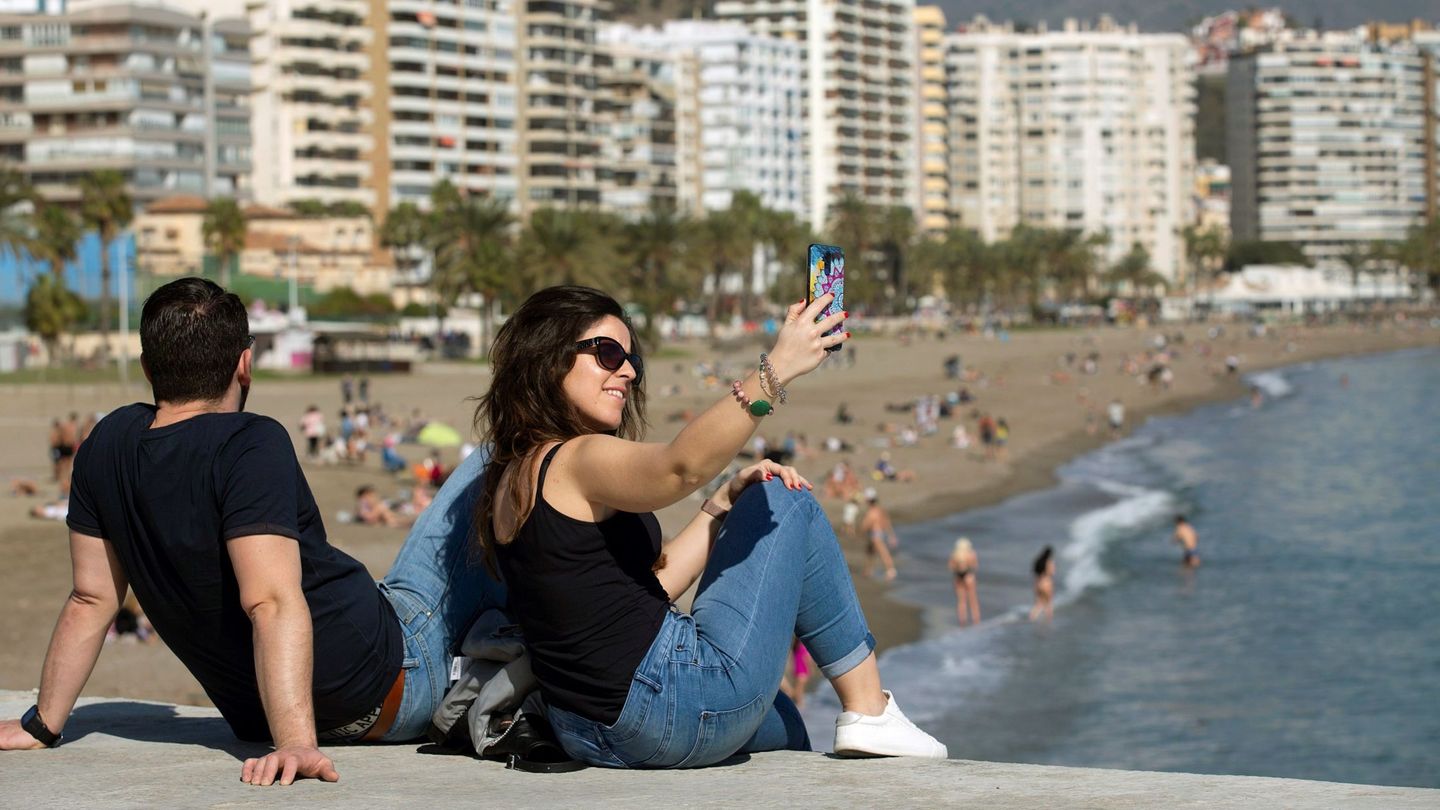 Una mujer tomándose una foto en una playa de Málaga. (EFE)