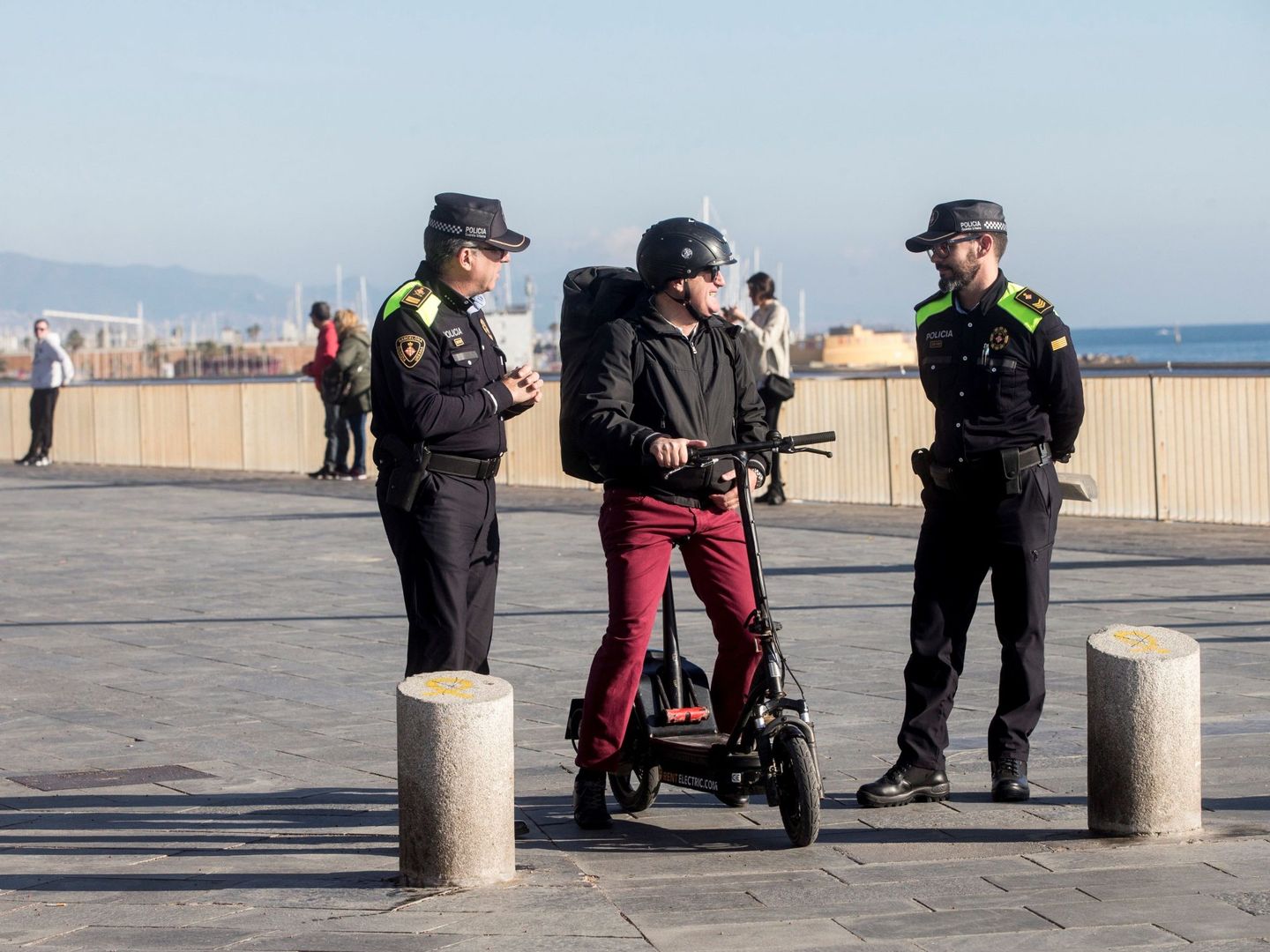 Agentes de la Guardia Urbana de Barcelona informan a un ciudadano, que circula con un patinete eléctrico, sobre la normativa de circulación. (EFE/Quique García)