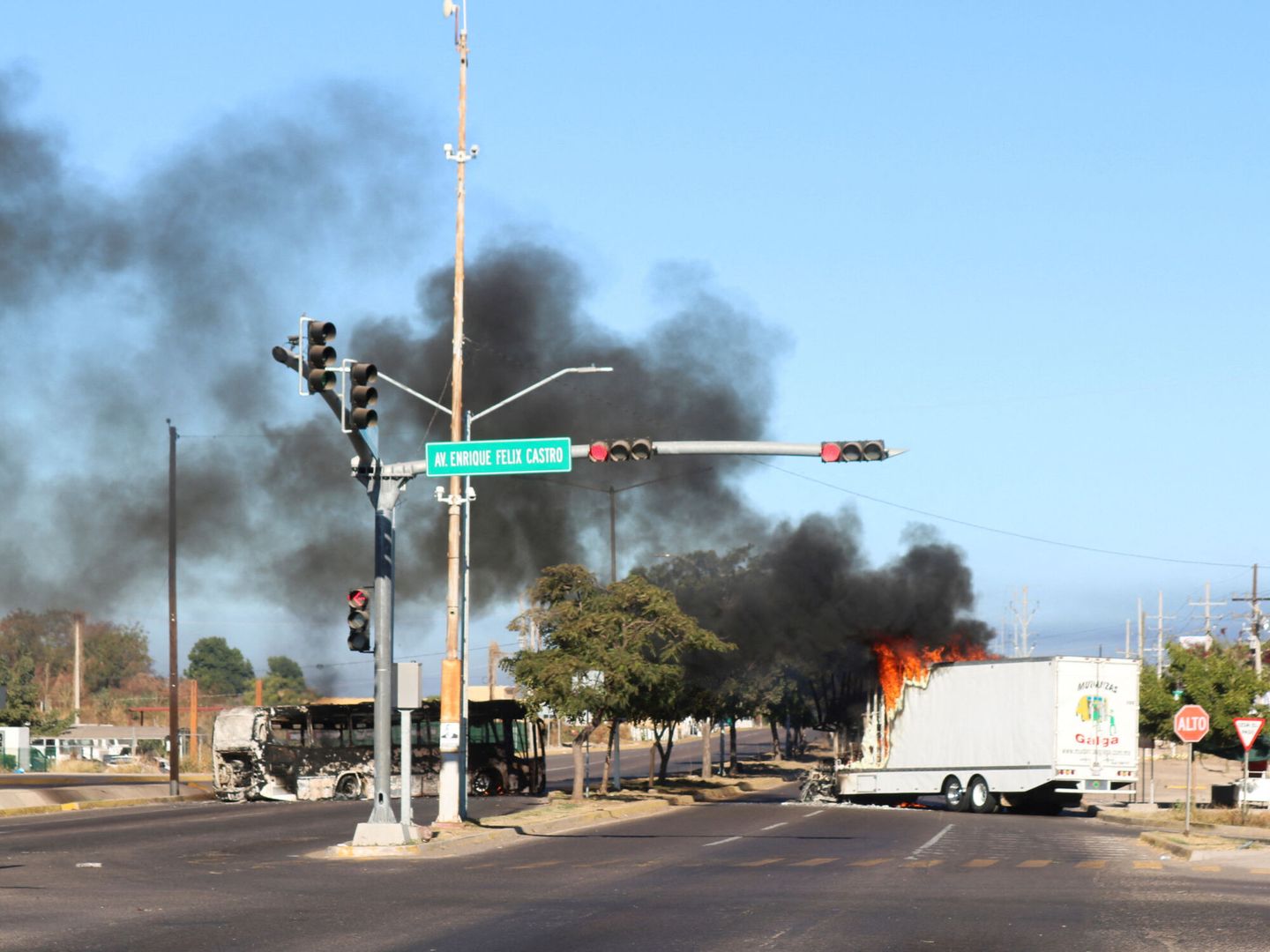 Imagen de los restos calcinados de un autobús y un camión incendiados tras la detención de Ovidio Guzmán. (Reuters/Stringer)