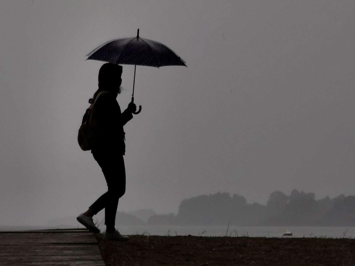 Foto: Una mujer pasea sosteniendo un paraguas en una imagen de archivo (EFE)