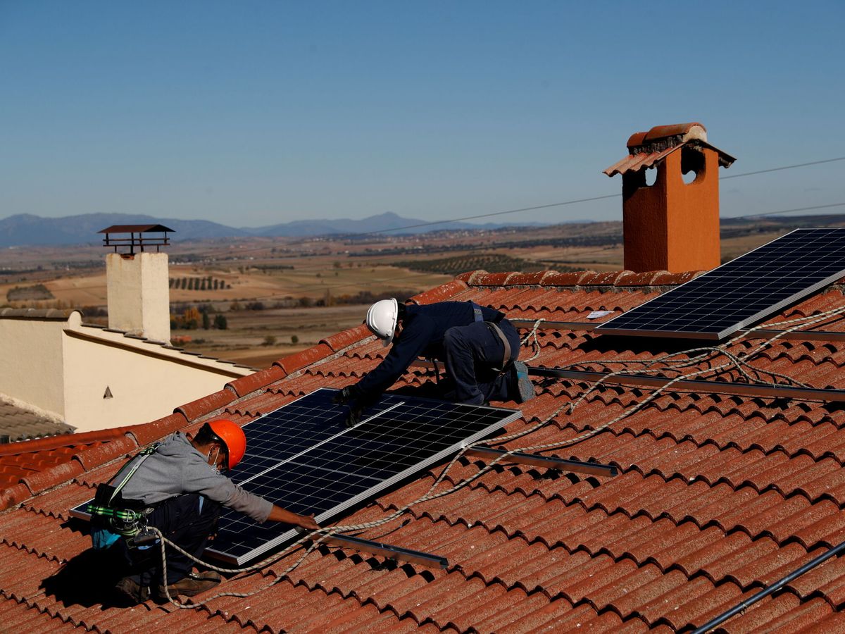 Foto: Dos técnicos instalando placas solares. (Reuters/Susana Vera)