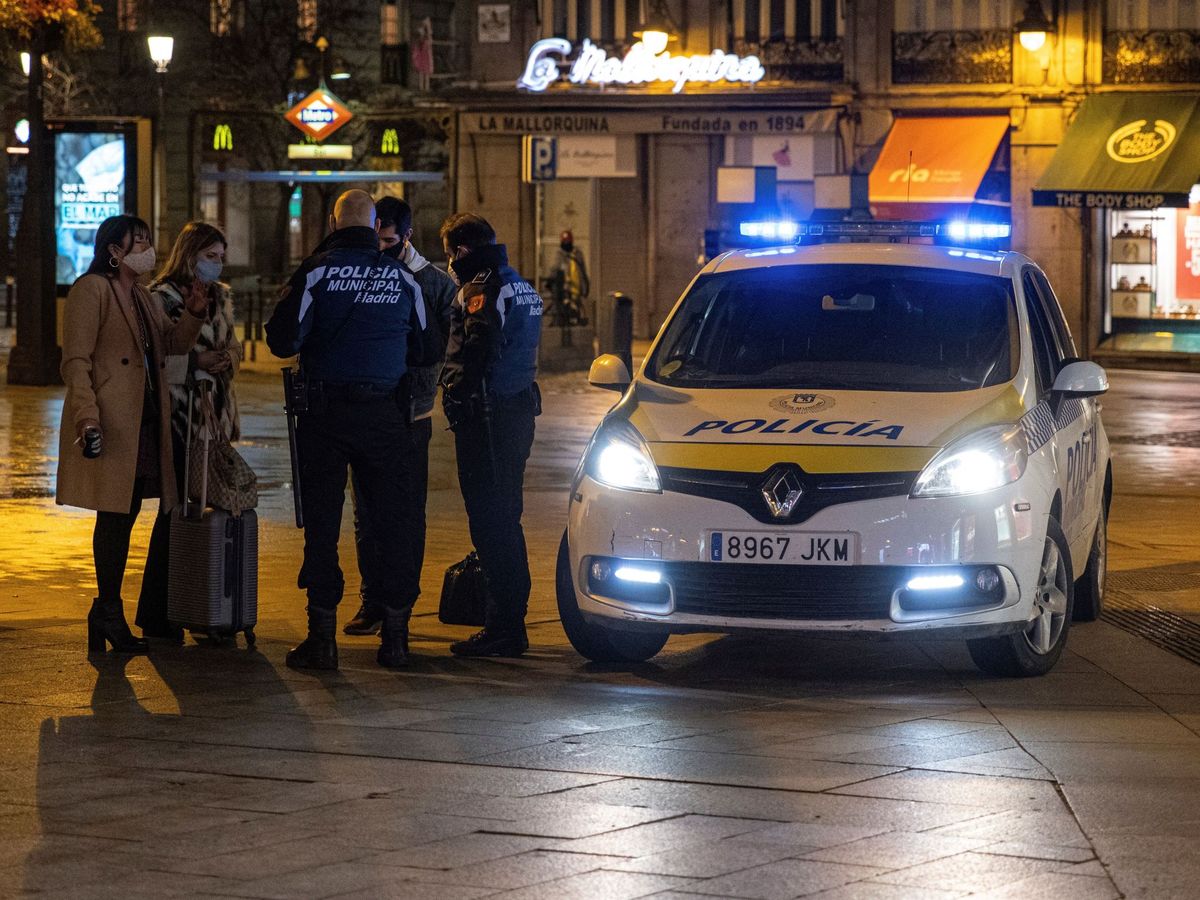 Foto: Dos policías municipales paran a viandantes en la Puerta del Sol, Madrid (EFE)
