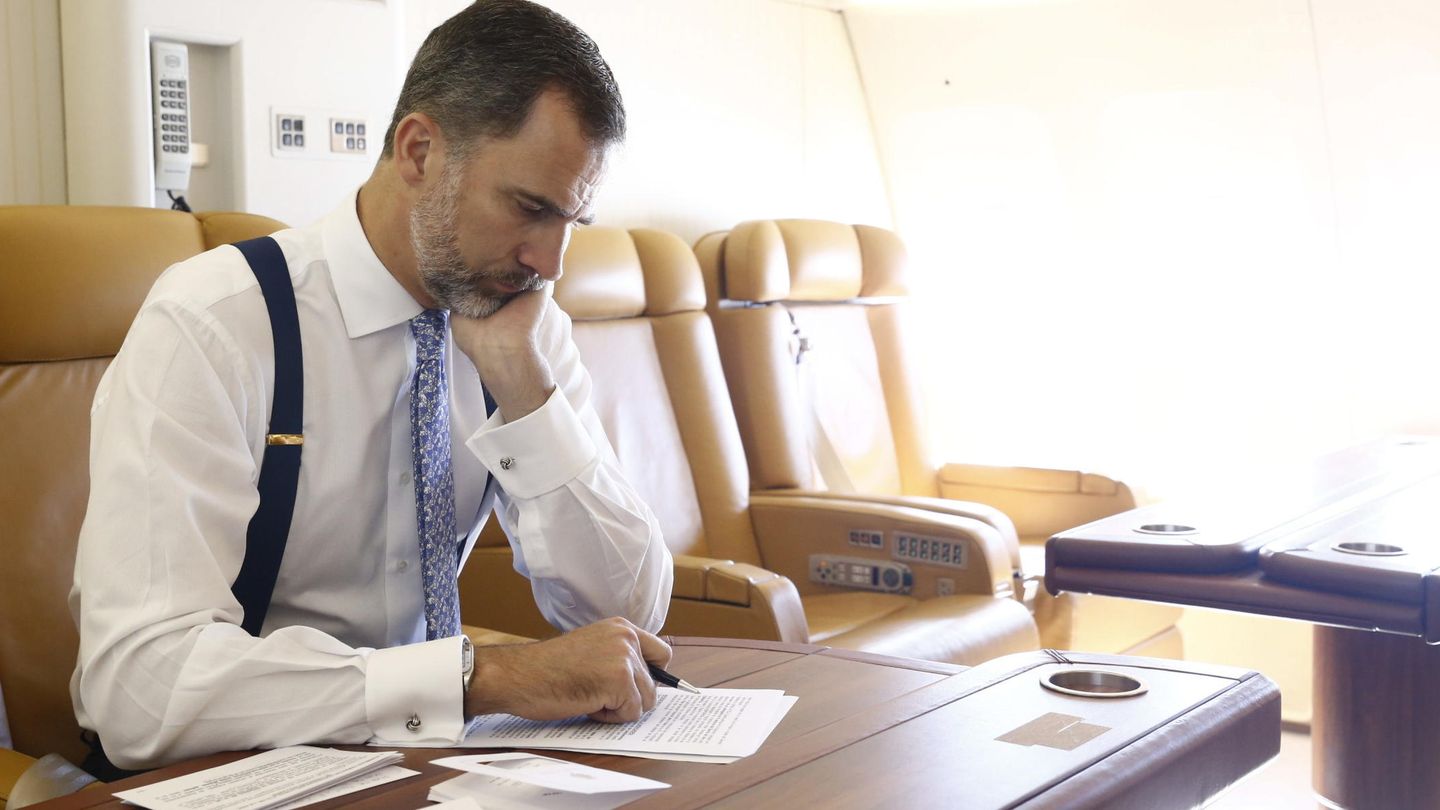 El Rey en el avión oficial preparando un discurso. (EFE)