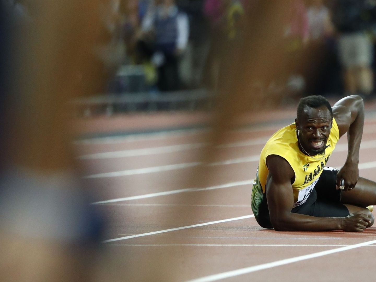 Bolt observa desde el suelo el final de la carrera de relevos. (EFE)