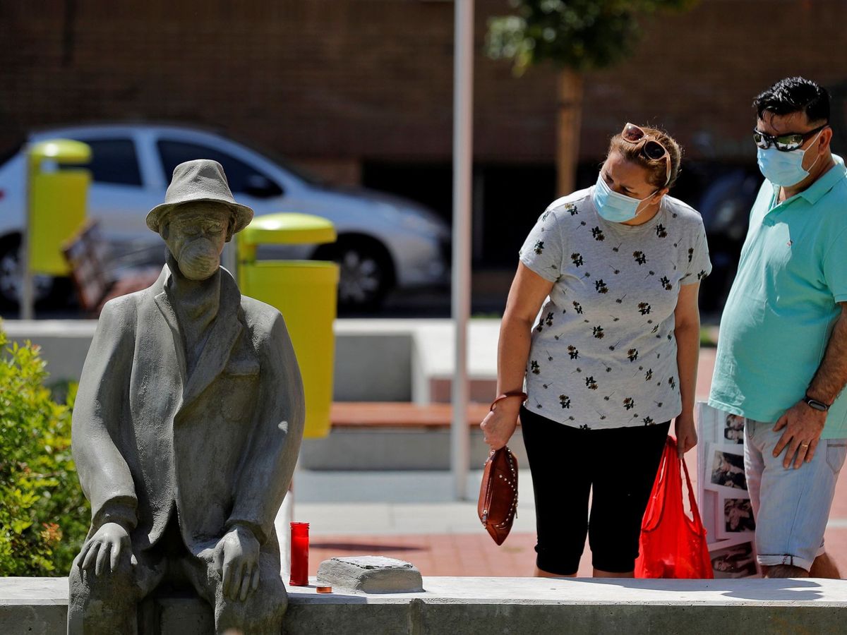 Foto: Dos personas observan la escultura, de autor desconocido, que ha aparecido en Benimamet. (EFE)