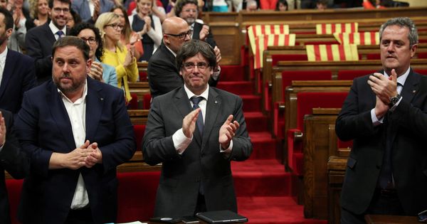 Foto: El presidente de la Generalitat, Carles Puigdemont (c), y su Gobierno celebran la aprobación de la ley del referéndum con los escaños vacíos de PSC, Ciudadanos y PPC. (Reuters)