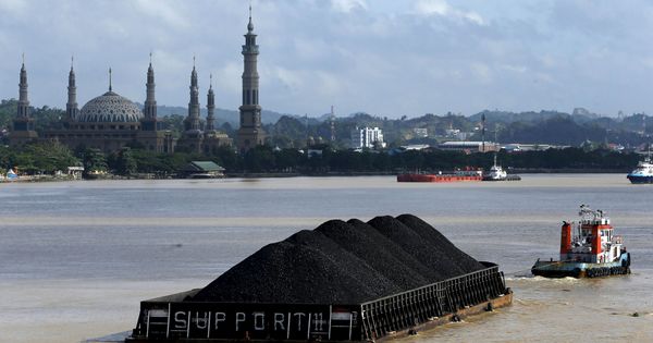 Foto: Un barco tira de una plataforma con carbón a lo largo del río Mahakam, en Indonesia (Reuters)