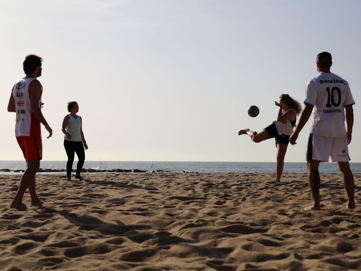 Foto: Cuatro personas juegan con el balón en la playa de la Barceloneta, en la capital catalana, este 8 de mayo. (Reuters)