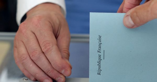 Foto: Un votante introduce la papeleta para elegir a los diputados de la Asamblea francesa durante la primera vuelta de las elecciones legislativas (Reuters)