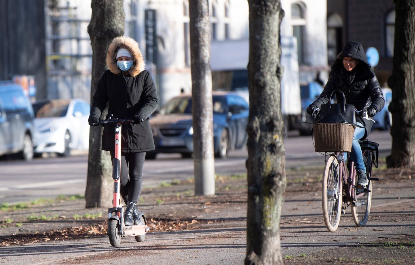 Mujer con patinete y mascarilla en Estocolmo. (Reuters) 