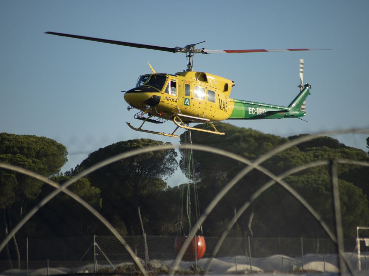 Foto: Un helicóptero participa en las labores de extinción. (EFE/David Arjona)