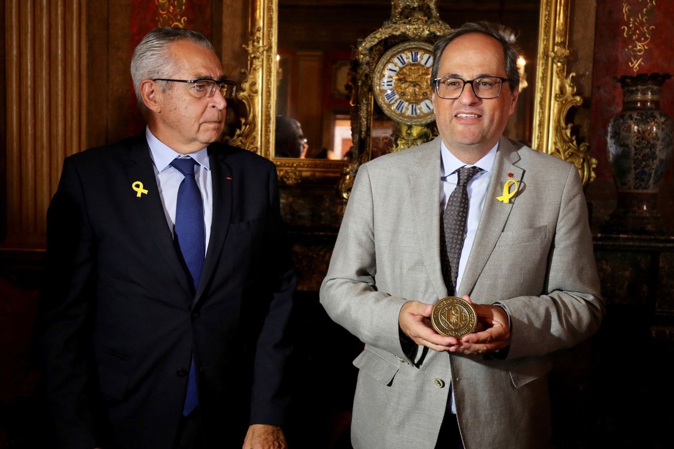 Jean-Marc Pujol, con Quim Torra, tras entregarle la medalla de honor y ponerse un lazo amarillo. (EFE)