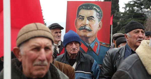 Foto: Estalinistas sostienen banderas de la URSS y retratos de Josif Stalin durante la celebración del 139 aniversario de su nacimiento en su ciudad natal, en Gori, Georgia. (EFE) 