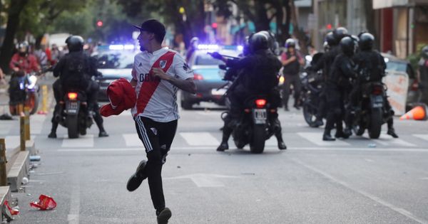 Foto: Un aficionado de River Plate corre frente a policías. (Reuters)