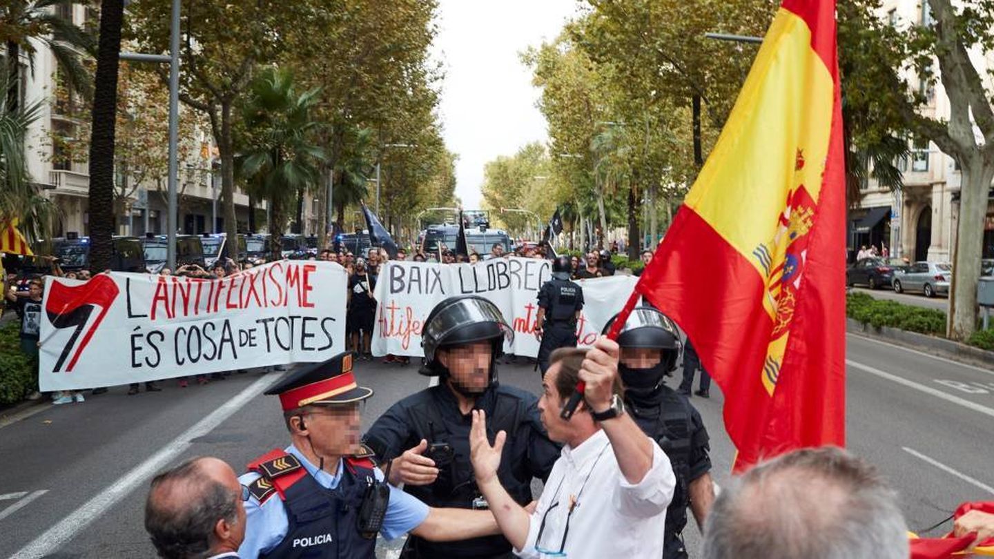 Un hombre con una bandera de España increpa a los manifestantes de la marcha antifascista de los CDR.