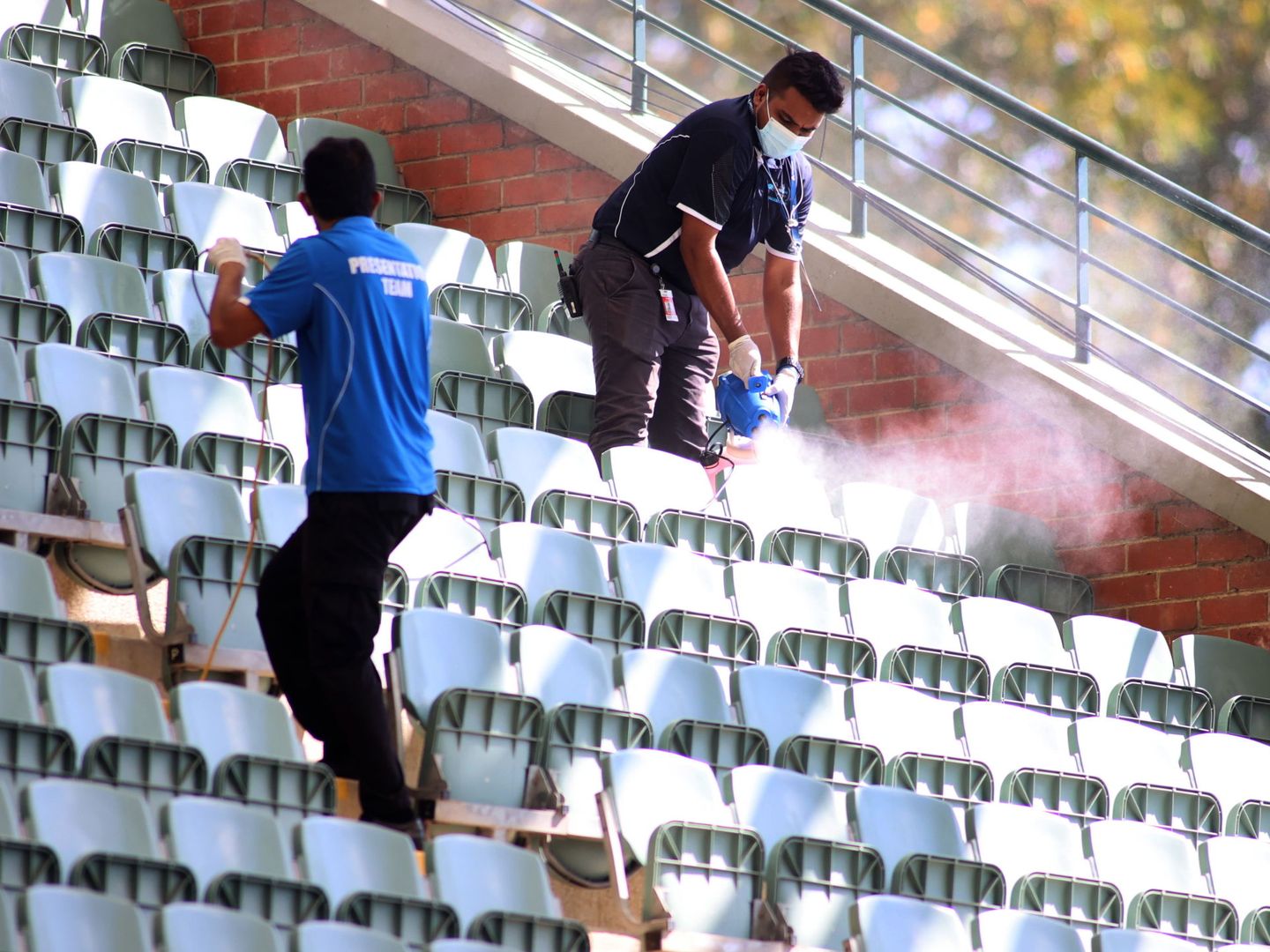 Limpiadores desinfectan las gradas antes de un partido de preparación al Open de Australia, este viernes pasado, en Adelaida. (Efe)