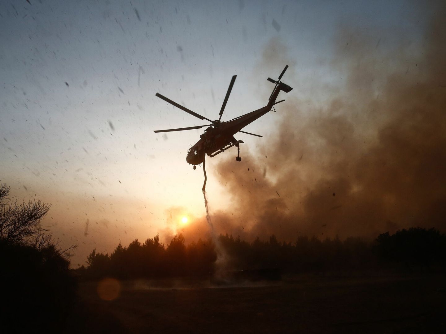 Un helicóptero trabaja para apagar el incendio en Varybobi. (EFE)
