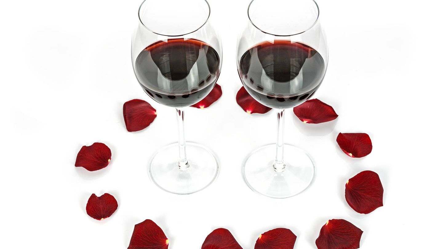 Prepara una cena romántica en casa con rosas y vino.