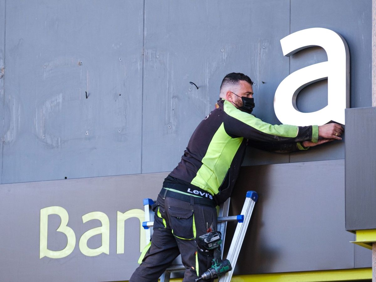 Foto: Operarios desmontan el rótulo de Bankia de la sede principal (EFE/Alonso)