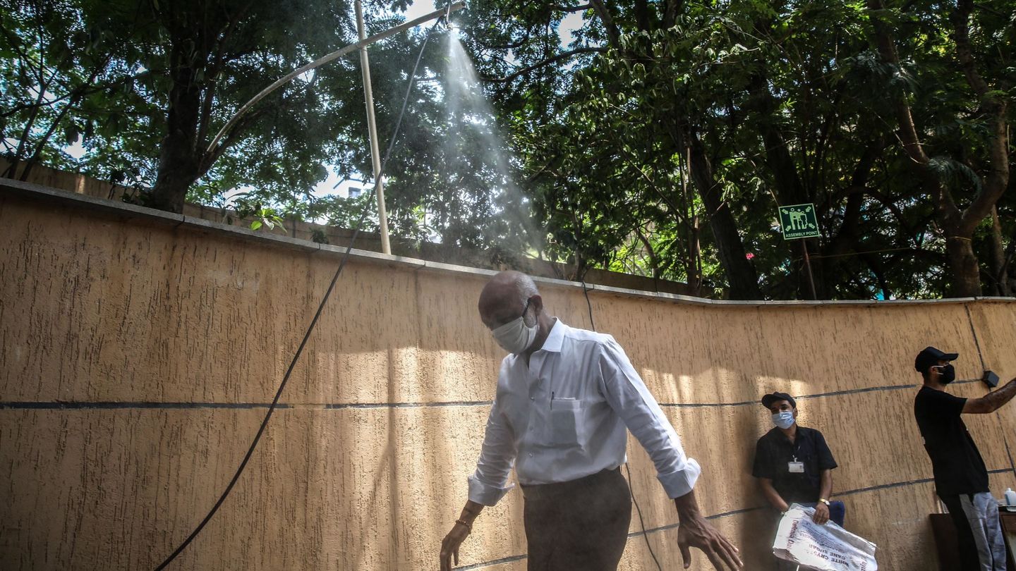 Un hombre pasa por una ducha desinfectante en Bombay, India. (EFE)