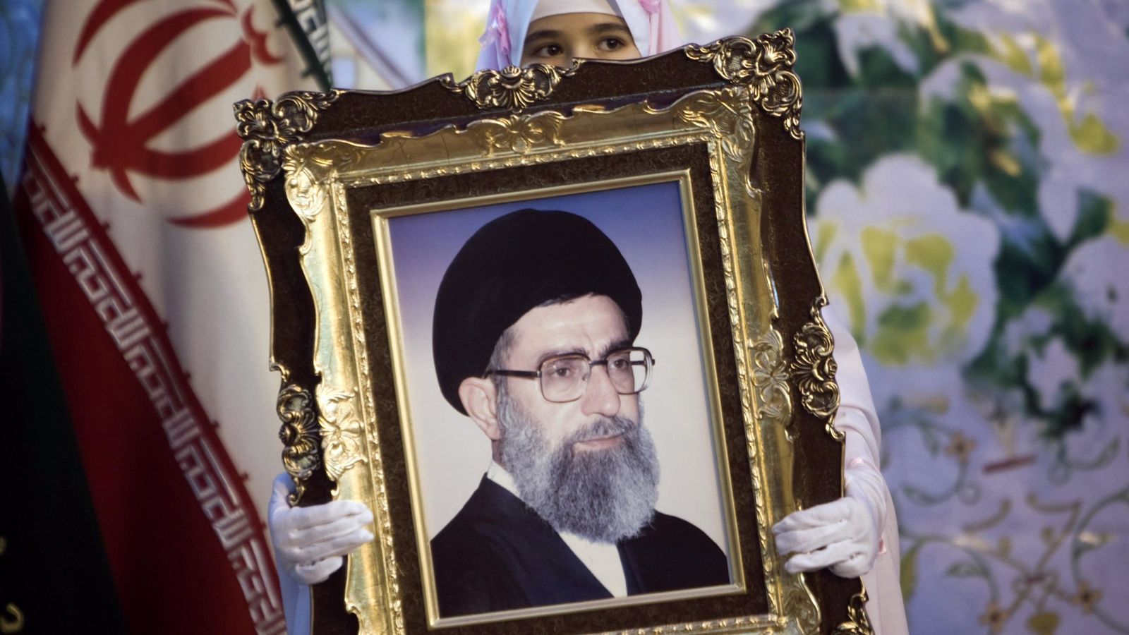 Foto: Una joven sostiene una fotografía del líder supremo de Irán, el ayatolá Alí Jamenei, en Teherán. (Reuters)