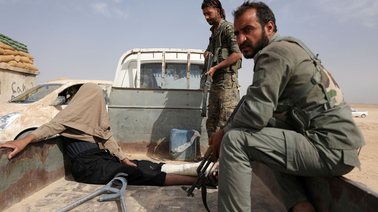 Foto: Combatientes de las SDF kurdas con un prisionero del ISIS en Deir al-Zor, Siria. (Reuters)