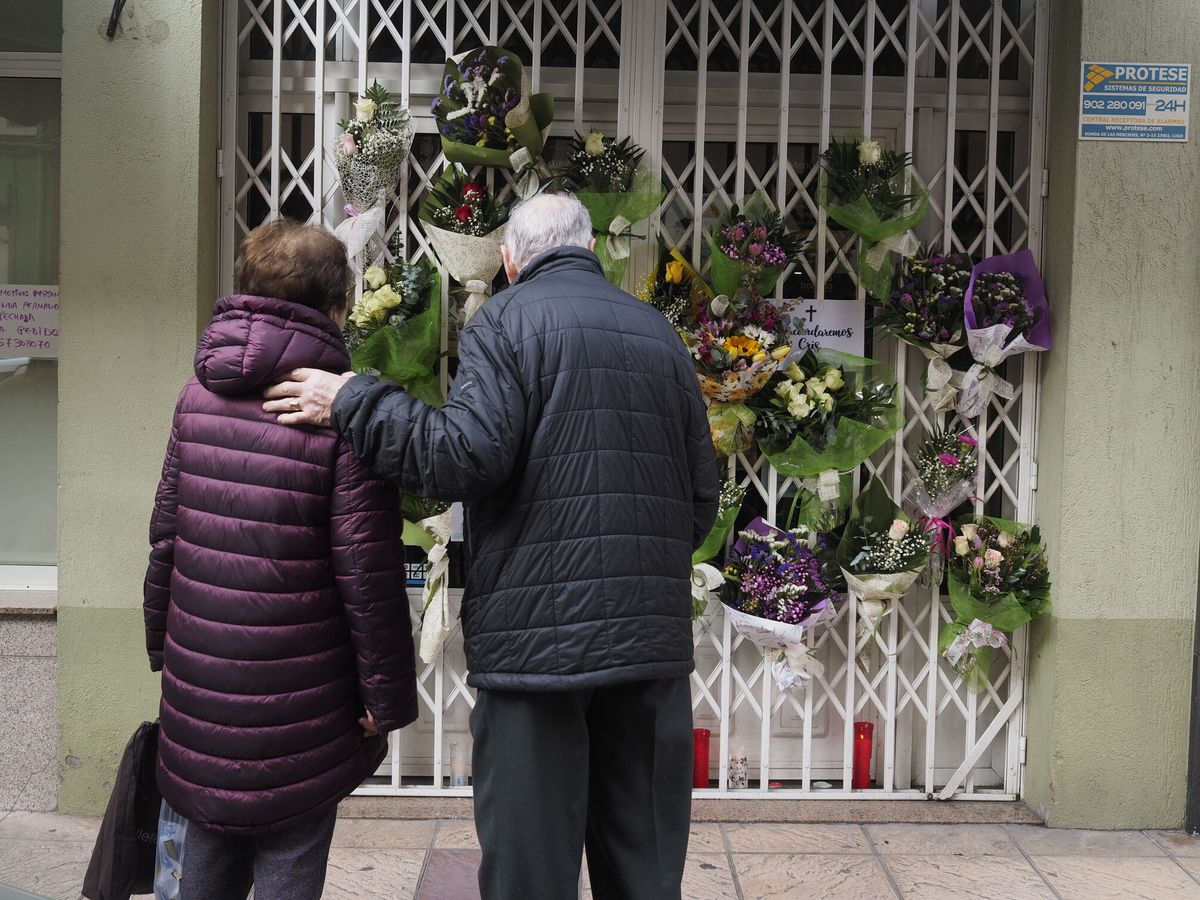 Foto:  Vecinos de la ciudad de Lugo dejan flores en la puerta de la tienda de la víctima. (EFE/Eliseo Trigo)