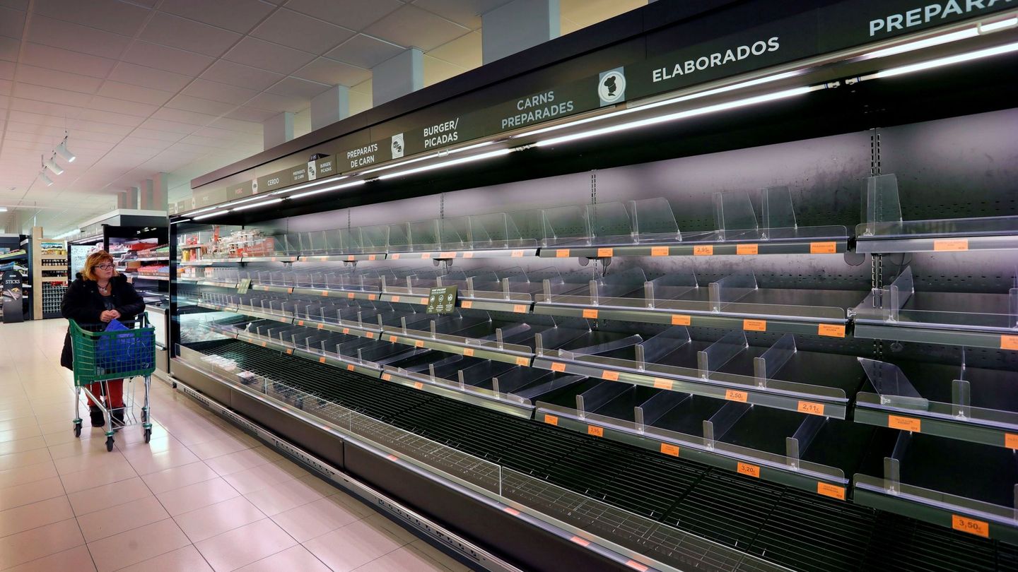 Una mujer observa los estantes vacíos de un supermercado de Igualada. (EFE)