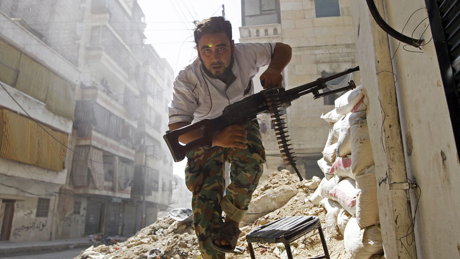 Foto: Un combatiente del ELS se pone a cubierto durante combates con el ejército sirio en el barrio Salaheddine, en el centro de Alepo (Reuters).  
