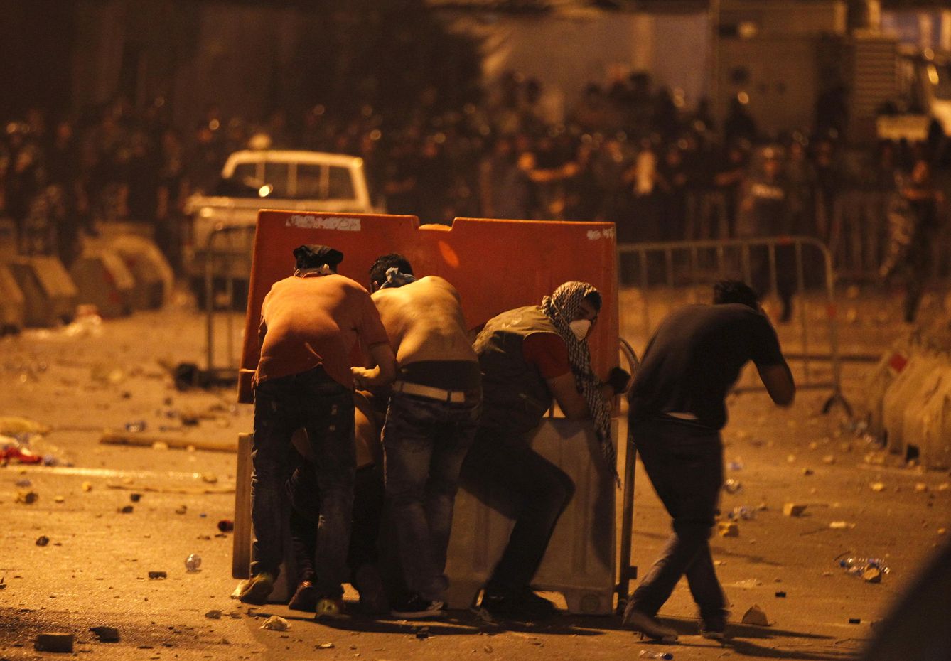 Foto: Manifestantes se cubren detrás de unas barricadas durante choques con policías antidisturbios en Beirut, el 23 de agosto de 2015 (Reuters).