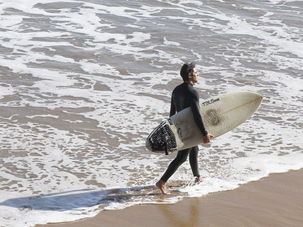 Foto: Un surfista en la playa de San Lorenzo de Gijón. (EFE)