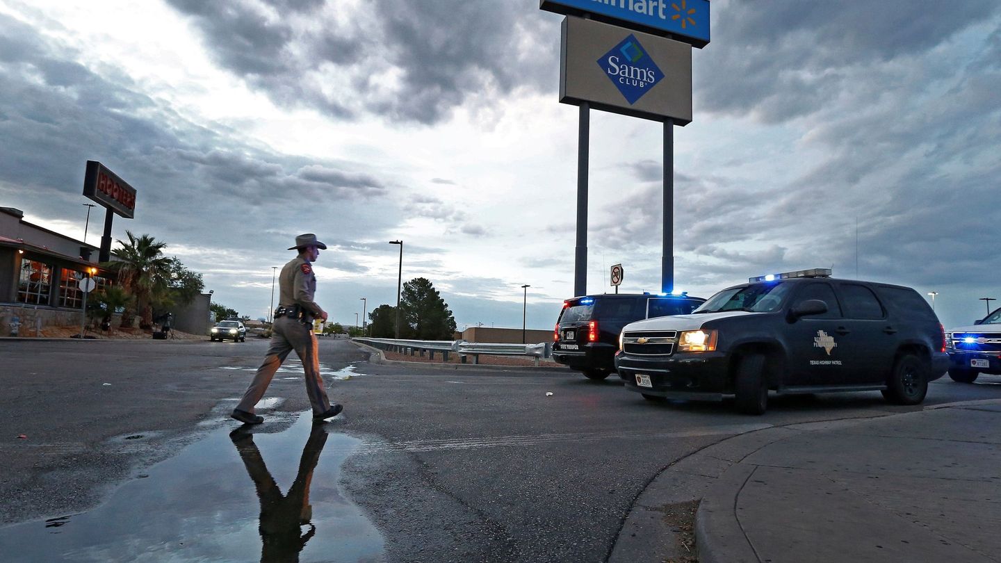 Un agente de las fuerzas de seguridad de Texas regresa a su vehículo, que bloquea una carretera, mientras continúa, este domingo, la investigación del tiroteo masivo perpetrado en un Walmart. (EFE)