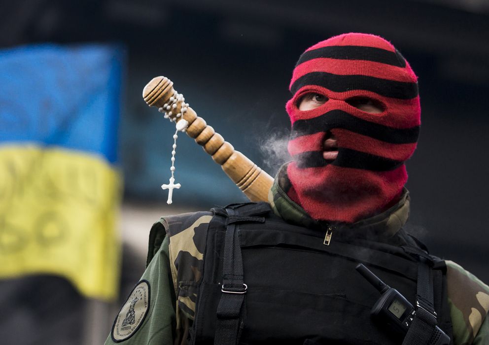 Foto: Un manifestante opositor observa a la Policía antidisturbios desde una barricada en Kiev. (Reuters)