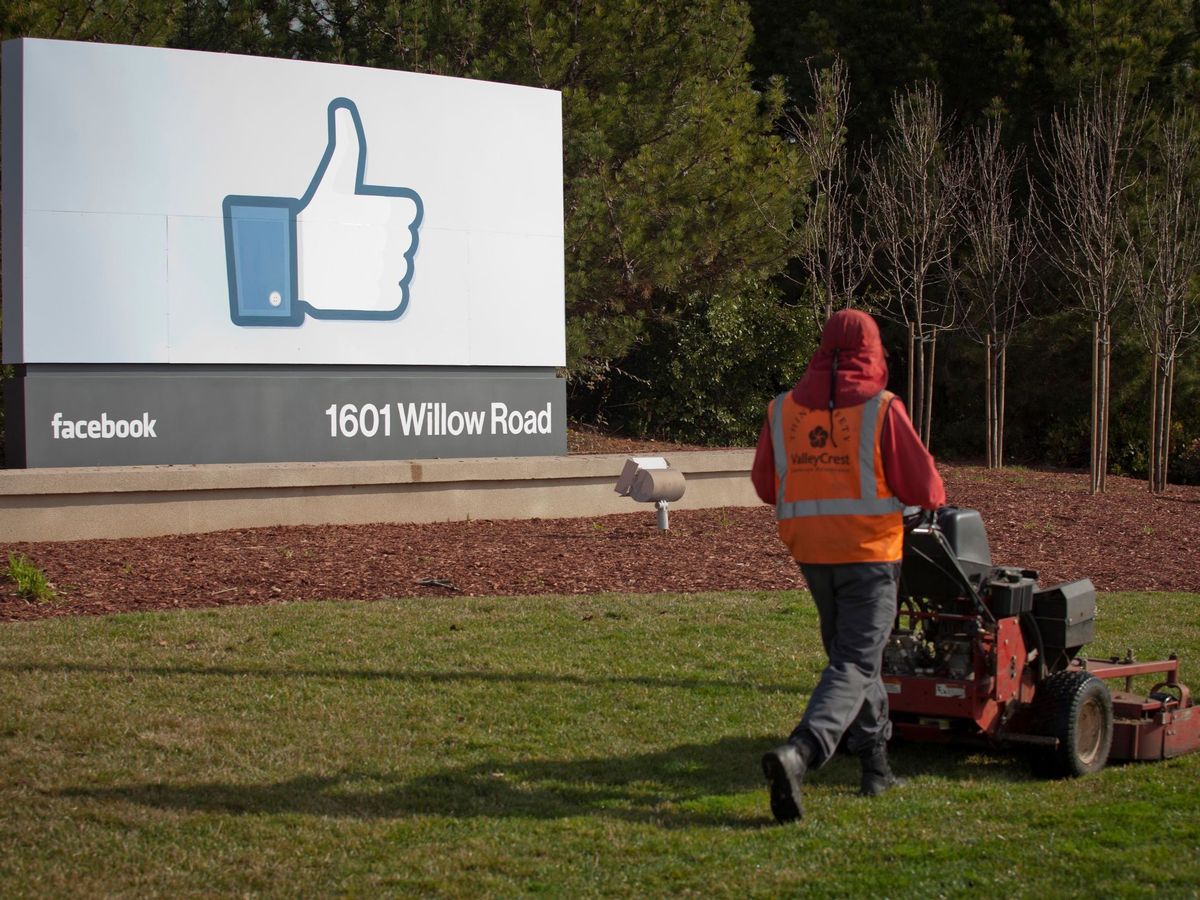 Foto: Un jardinero corta el césped frente a la sede de Facebook, en Menlo Park (California, Estados Unidos). (EFE)