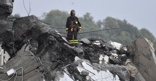 Foto: Un bombero permanece sobre los escombros del puente derrumbado en Génova. (EFE)