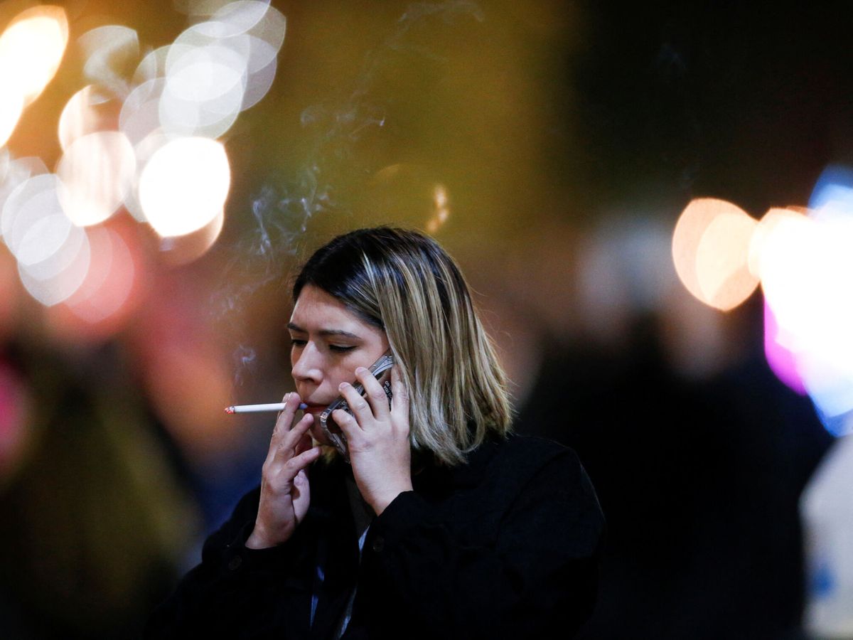 Foto: Una mujer fumando en la calle. (Reuters/Daniel Becerril)