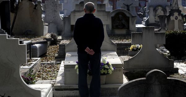 Foto: Un hombre frente a una sepultura en el cementerio de La Almudena de Madrid. (EFE)