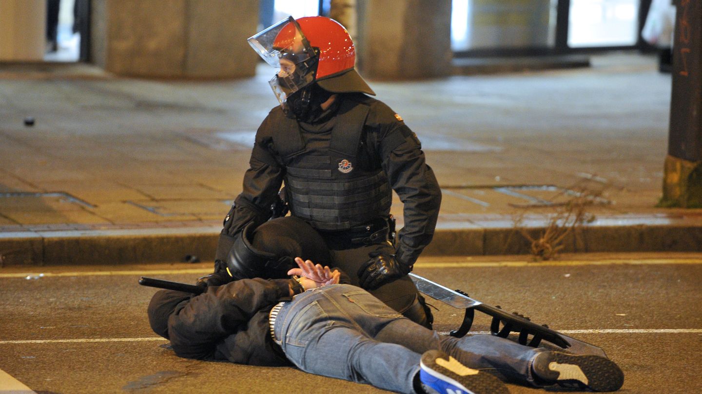 Un 'ertzaina' detiene a una persona durante los incidentes entre aficionados del Spartak y el Athletic el 22 de febrero. (Reuters)