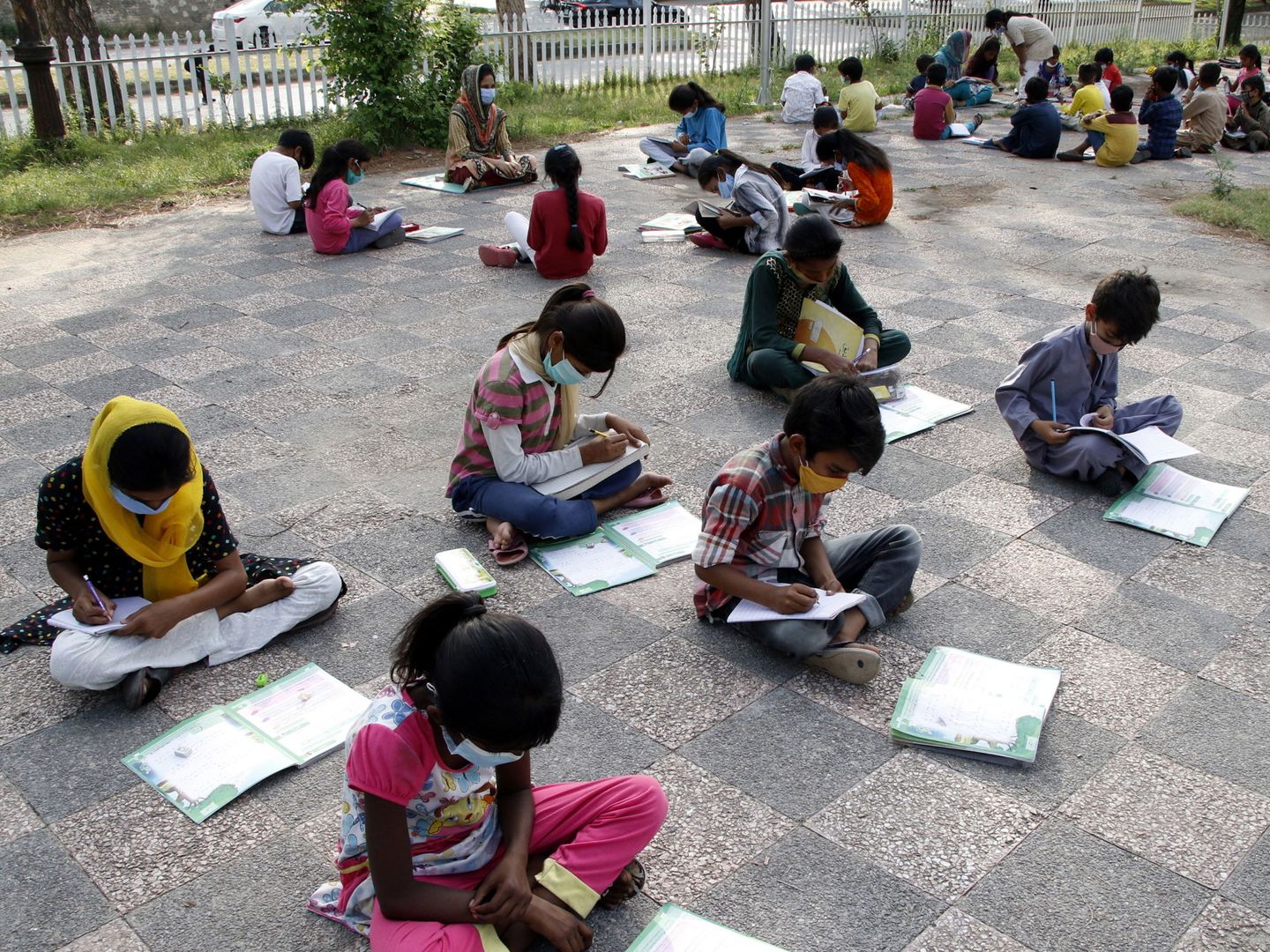 Niños y niñas estudian al aire libre en una favela de Islamabad (Pakistan). (EFE)