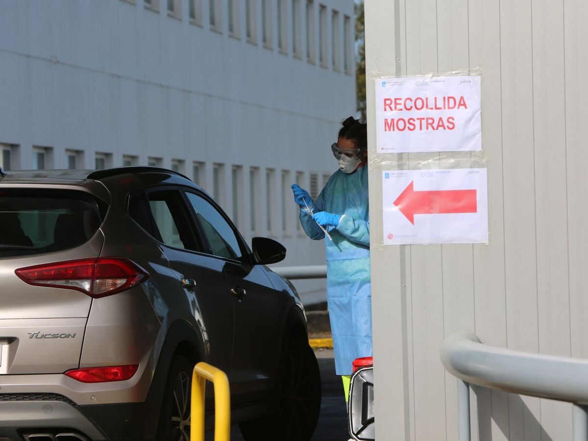 Foto: Una trabajadora sanitaria recoge muestras para realizar la prueba del coronavirus a posibles infectados en el hospital de Meixoeiro, en Vigo. (EFE)