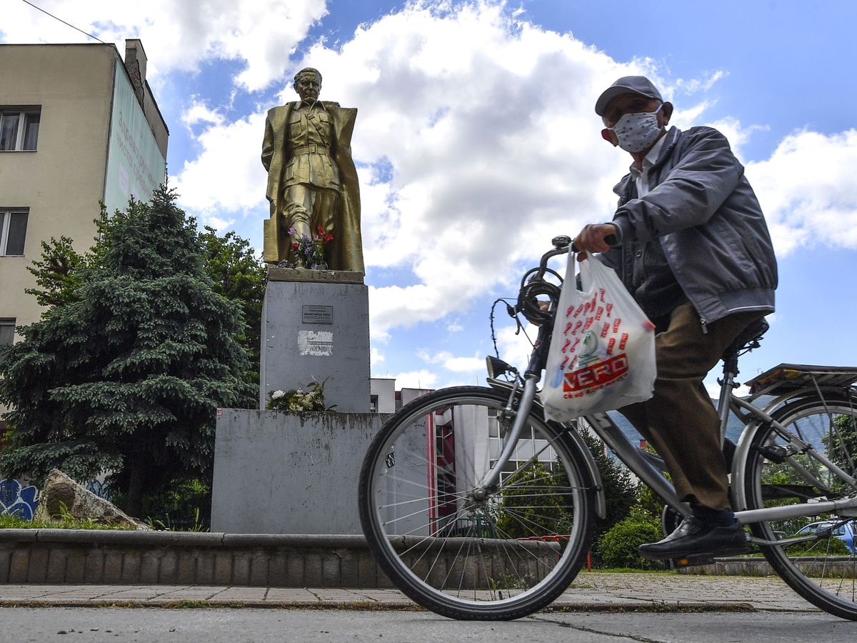 Foto: Una persona pasa por delante de la estatua de Tito, en Macedonia del Norte. (EFE/Georgi Licovski)