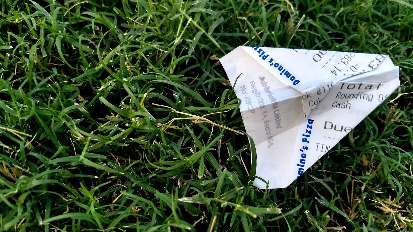 Un avión de papel hecho con un 'ticket' de compra (Pexels)