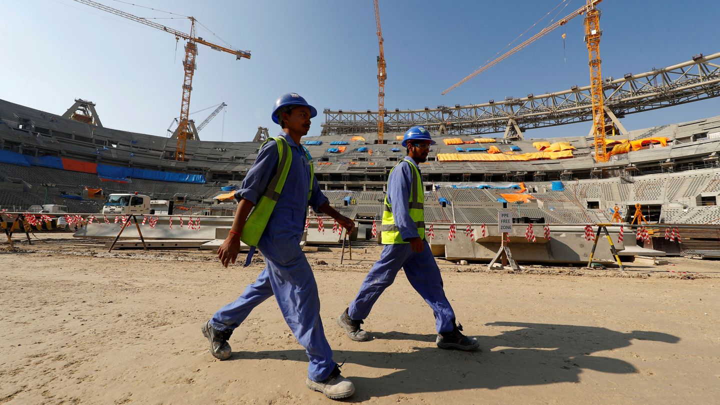 Dos trabajadores pasean por uno de los estadios del Mundial de Qatar, en 2019. (Reuters)