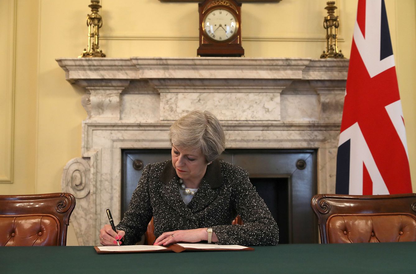 Theresa May firmando la carta con la que pide activar el artículo 50. (Reuters)