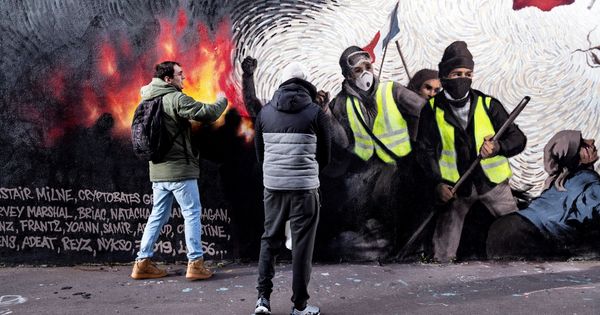 Foto: Dos jóvenes buscan pistas para obtener una recompensa en un mural del artista francés Pascal Boyart sobre los 'chalecos amarillos', en París. (EFE)