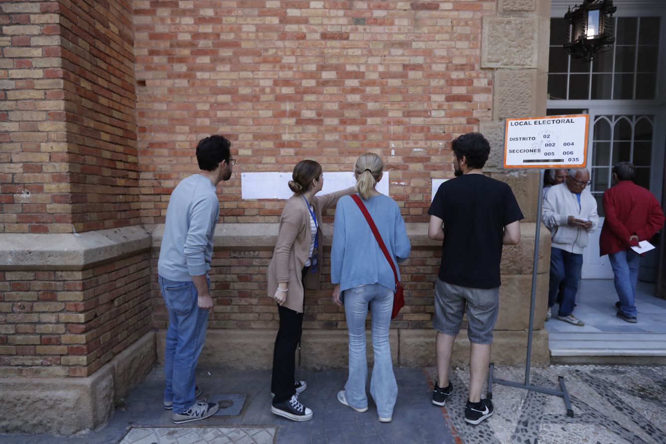Varios votantes revisan el censo antes de acceder al colegio electoral. (EFE/Jorge Zapata)